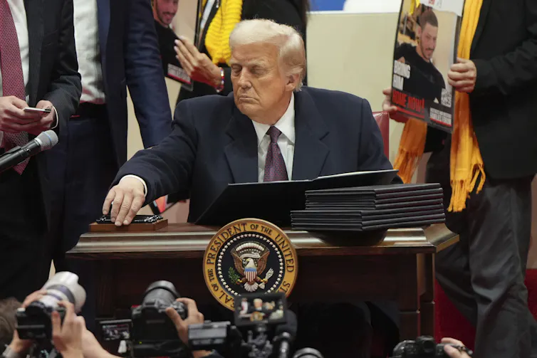 President Donald Trump sign an executive order on his first day in office.