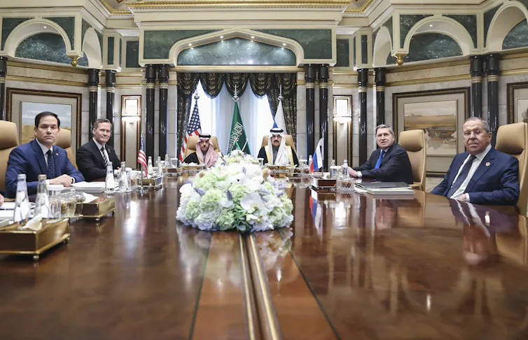 Russian and American officials at a long table.