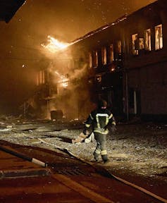Ukrainian saviors work in the site of a drone strike at a private factory in Kharkiv, Northeast Ukraine