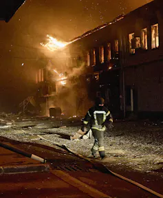 Ukrainian rescuers work at the site of a drone strike on a private factory in Kharkiv, northeastern Ukraine