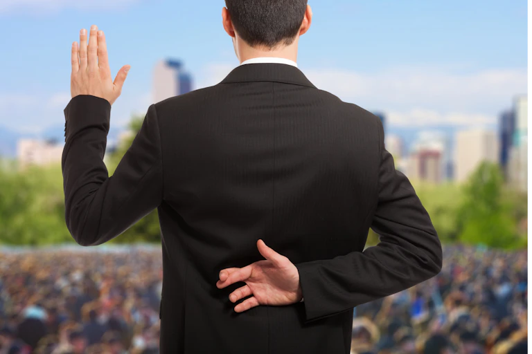 Politician swearing an oath with fingers crossed behind back