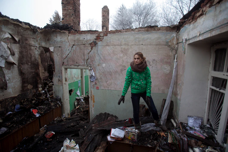 Une jeune femme récupère des objets dans les décombres d'une clinique où elle travaillait, détruite par une frappe par des rebelles pro-russes, dans la région de Donetsk, le 15 février 2015.