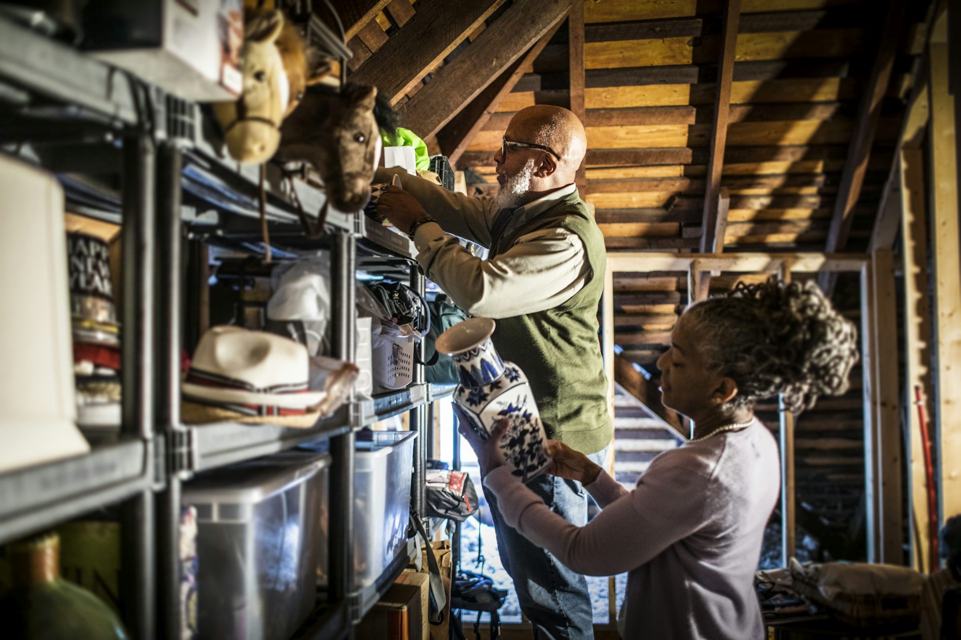 Casal de idosos organizando itens no sótão da casa