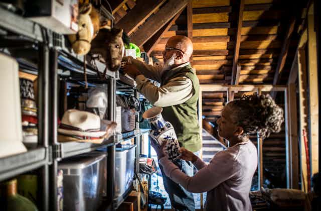 Casal de idosos organizando itens no sótão da casa