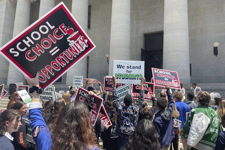 a group of people stand outside a courthouse holding signs such as 'school choice = opportunity'
