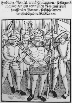 A black-and-white sketch showing several people standing with spears and other weapons.