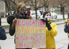Personas vistas con el letrero, los estudiantes de educación contra los 21 años '