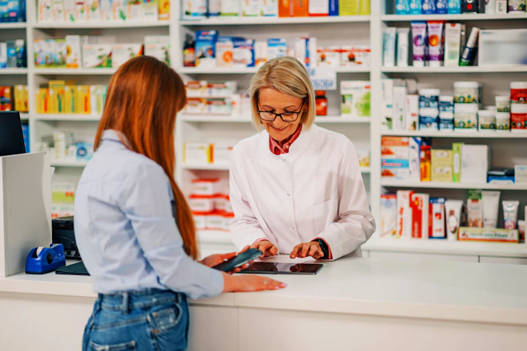 A young woman speaking to a female pharmacist.