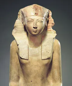 Uma estátua de arenito de Hatshepsut em um cocar de faraó.