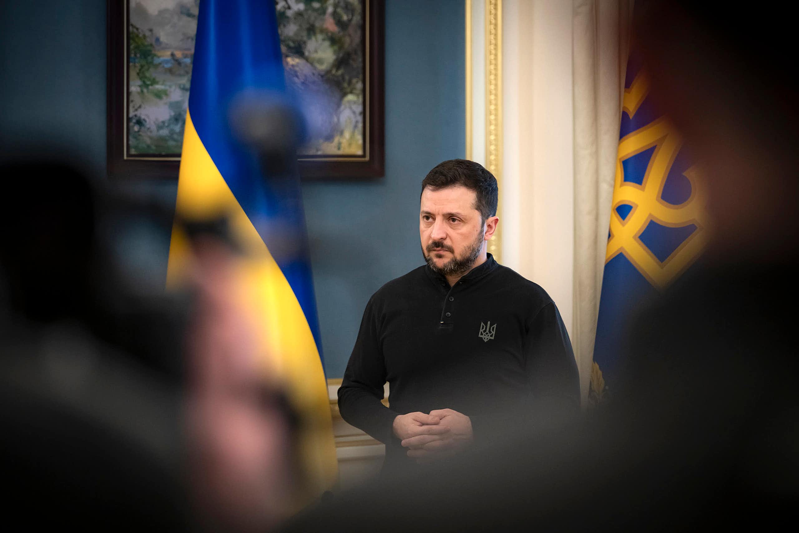 Ukraine's president Volodymyr Zelensky, flanked by his country's flags.