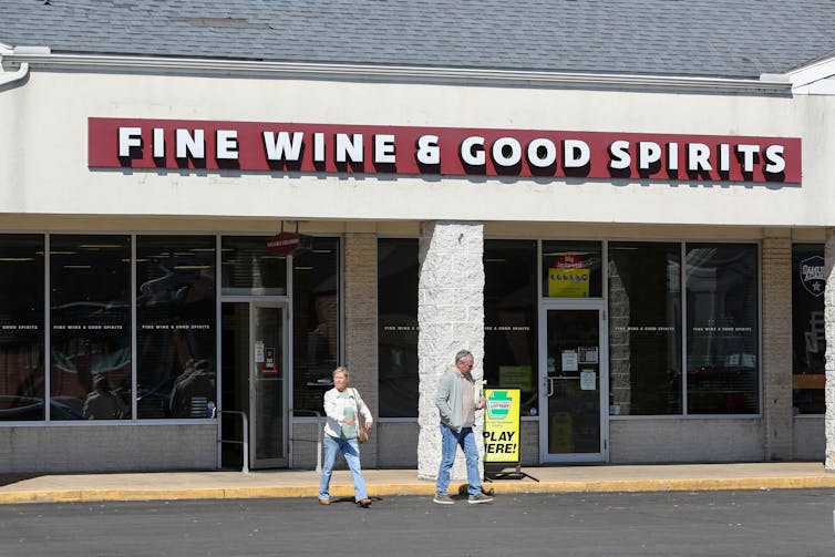 As Pennsylvania Inches Toward Legalizing Recreational Cannabis, Lawmakers Propose Selling It in State-owned Dispensaries Similar to State Liquor Stores 2 Man and woman crossing street in front of a store with sign that reads: Fine Wine & Good Spirits