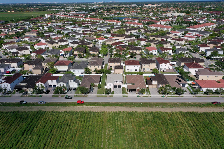 In an aerial view, single-family homes are shown in a residential neighborhood in the Miami metro area.