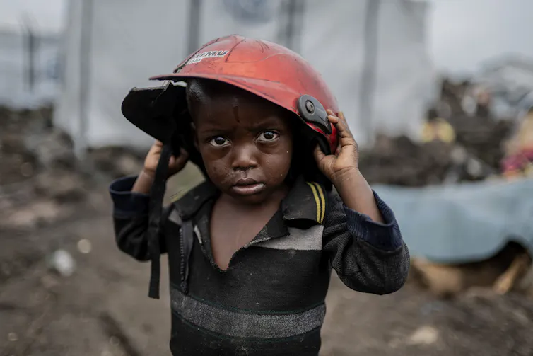 a small child wearing a too-large helmet