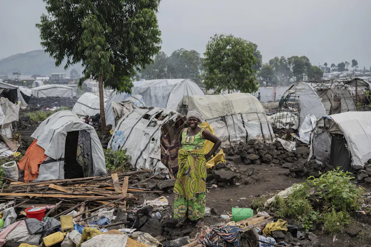 a woman standing in a refugee camp