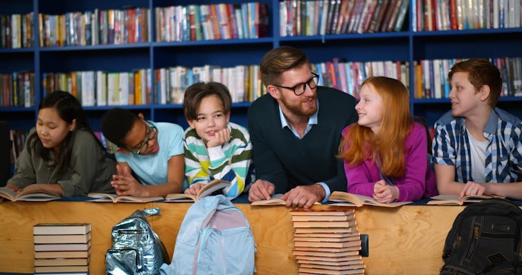 A male teacher with young students.