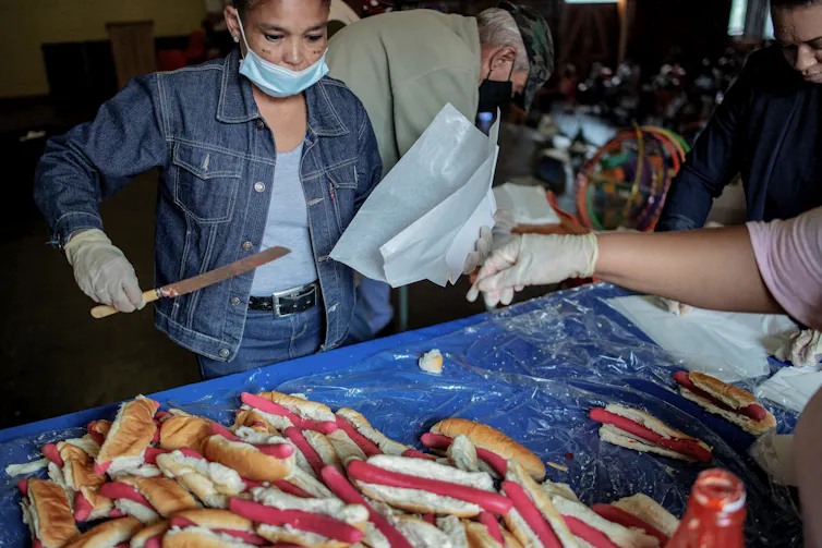 Volunteers from the charity Hunger Has No Religion prepare hotdogs for hungry people in Coronationville, Johannesburg.