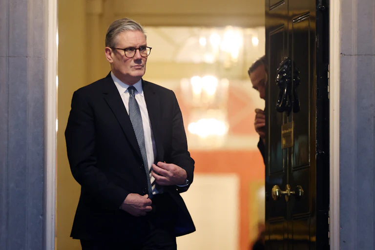 Starmer standing in the doorway of Number 10 in the evening, with a very serious expression on his face