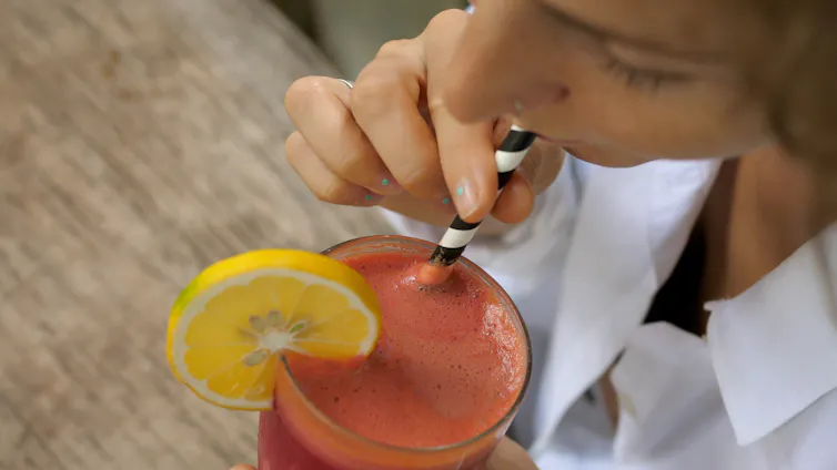 Woman drinks smoothie with paper straw