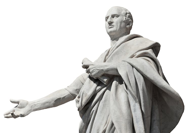 White statue of balding man wearing a loose tunic and holding a scroll.