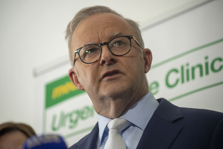 Anthony Albanese pictured in front of a Medicare clinic sign