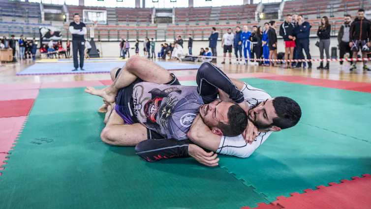 A jiu-jitsu practitioner applying the rear naked choke to his opponent.