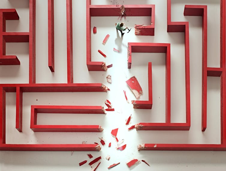 Illustration of red maze with small, axe-wielding figure chopping through the walls.