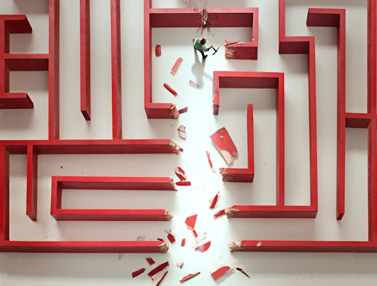 Illustration of red maze with small, axe-wielding figure chopping through the walls.