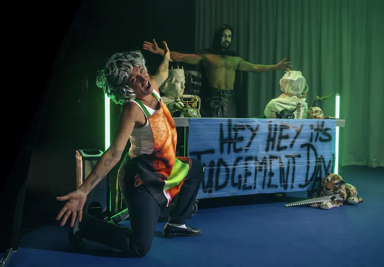 A sign reads Hey Hey It's Judgment Day, two actors appear to be saying ta-da.