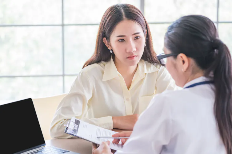 Young woman talks to a doctor.