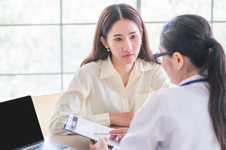 Young woman talks to a doctor.