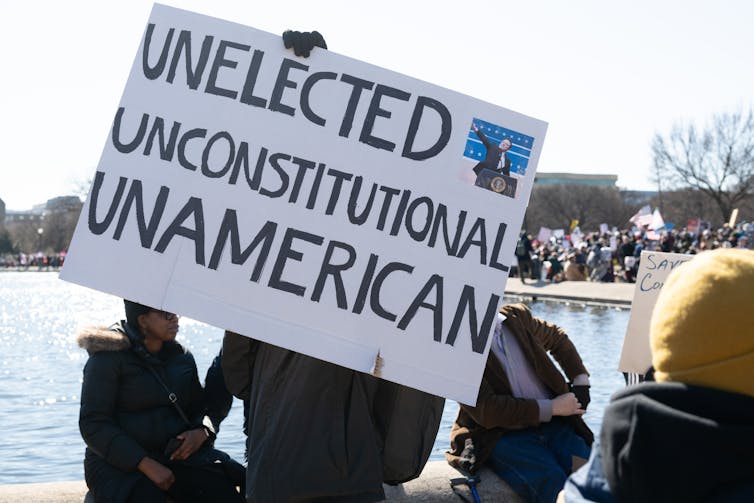 Several people holding a protest banner