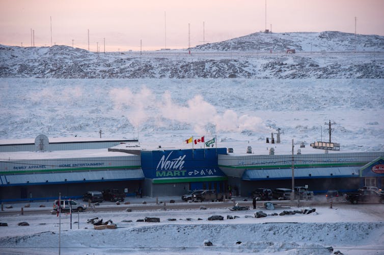 Un gran edificio con las palabras North March escribió en la nieve cubierta de un paisaje.