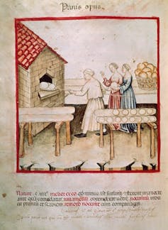 A faded illustration of three women putting a loaf of bread into a large kiln.