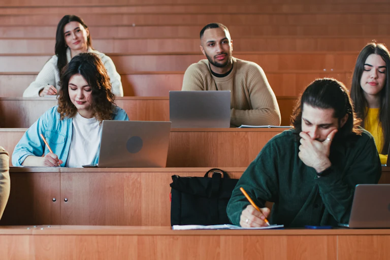 University students in a lecture hall with laptops and notebooks