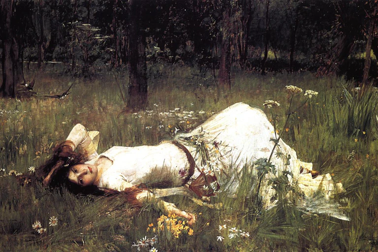 Una mujer con vestido blanco tumbada en un campo de flores.