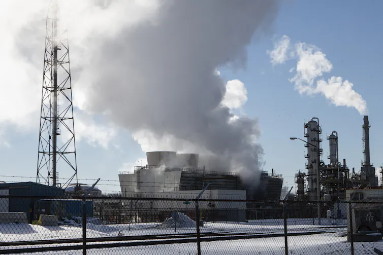 Azulejos de humo que se elevan en la atmósfera de las plantas petroquímicas.