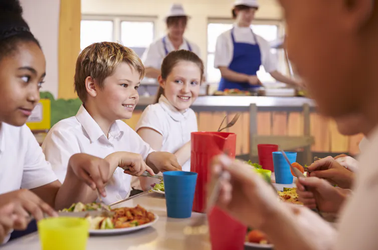 Primary school children at a table in school canteen.