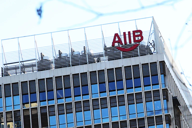 A large building has the letters AIIB displayed on the top.