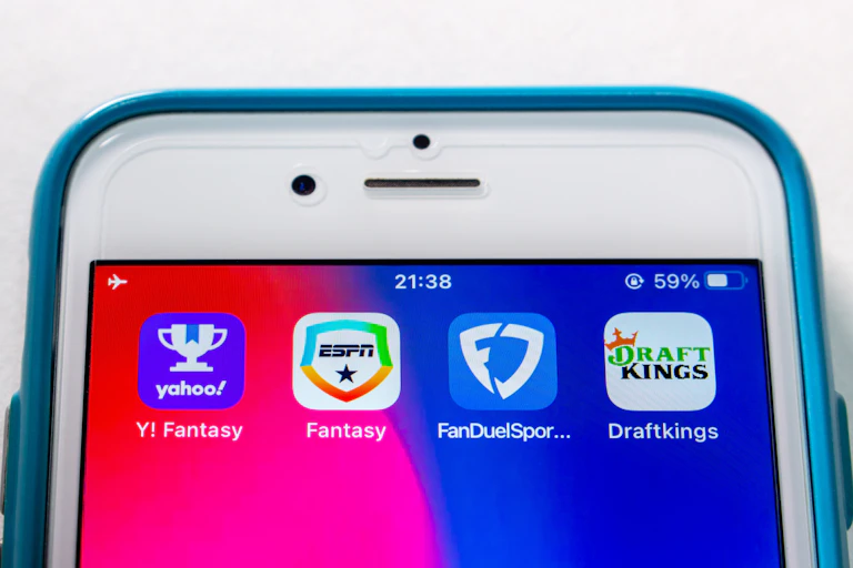 Icons of Yahoo Fantasy Sports, ESPN Fantasy Sports, FanDuel Fantasy Sports and Draftking on an iPhone.