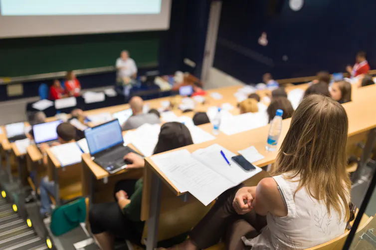 Students in a lecture hall taking notes