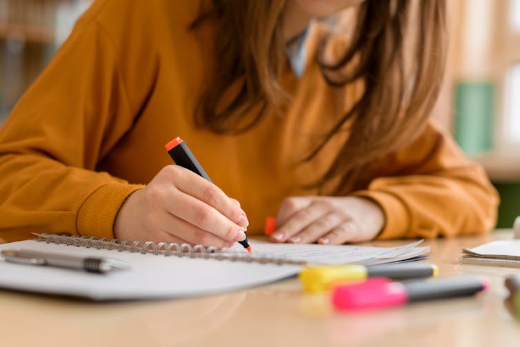 Woman highlighting words in a notebook