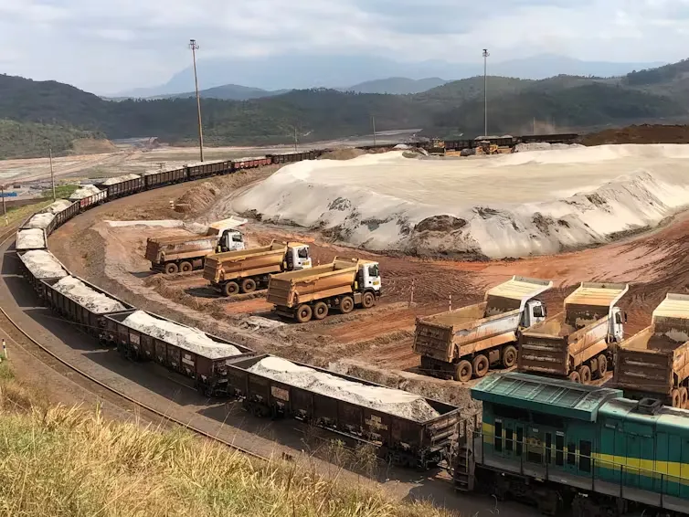 iron ore mine with a manufactured sand pile in background.