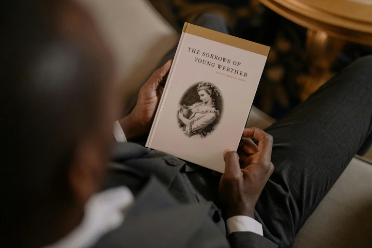 A man holds a copy of The Sorrows of Young Werther