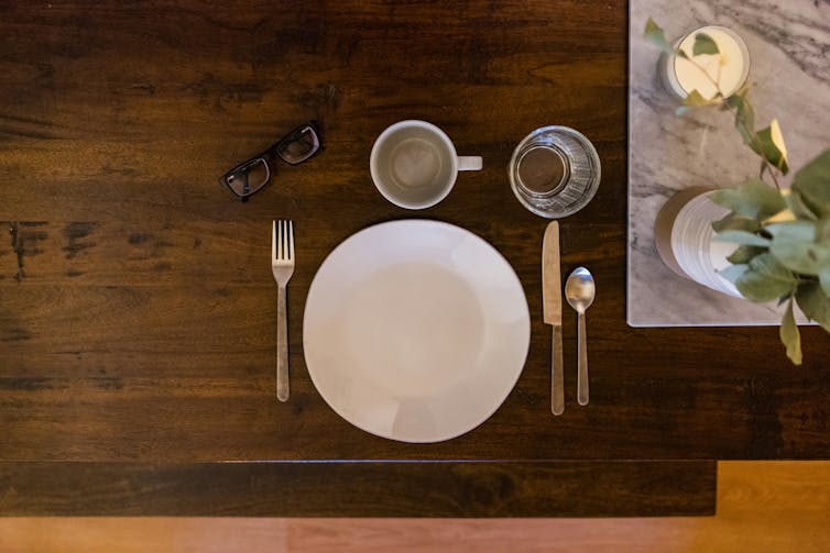 a plate, cutlery, a mug and a glass on a table, with glasses