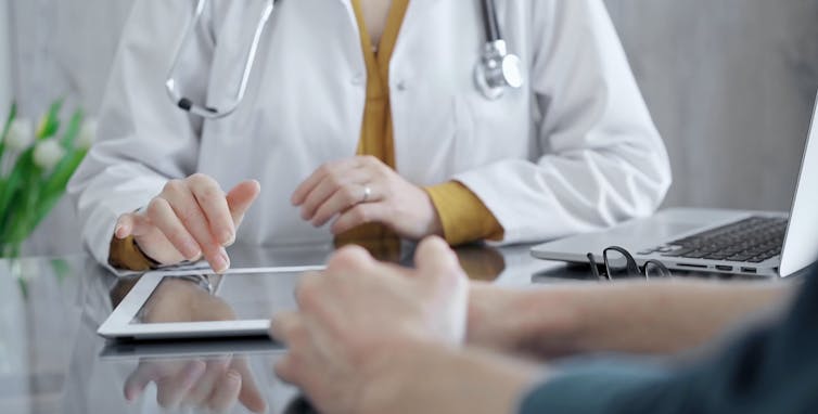 doctor with iPad and patient opposite