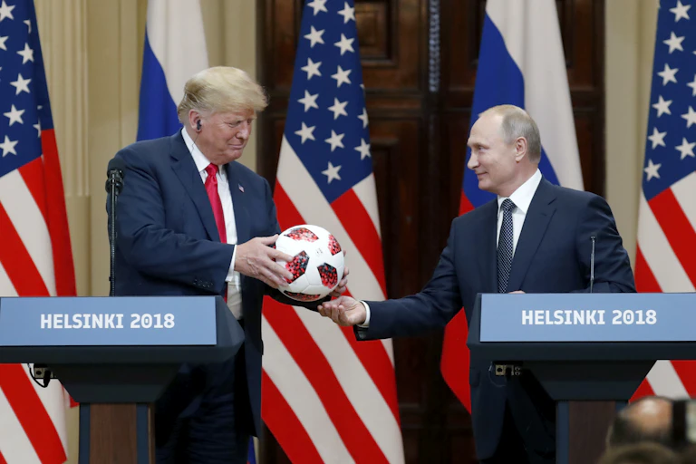 Donald Trump receives a football from Vladimir Putin