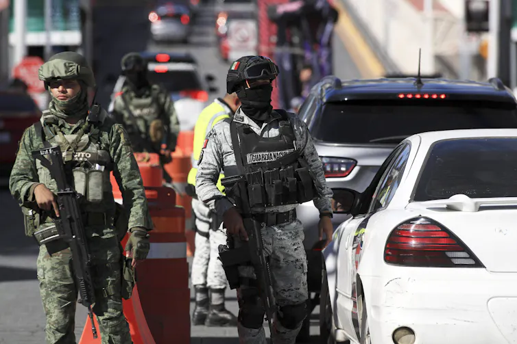 Members of the Mexican military stand guard at the US border crossing.