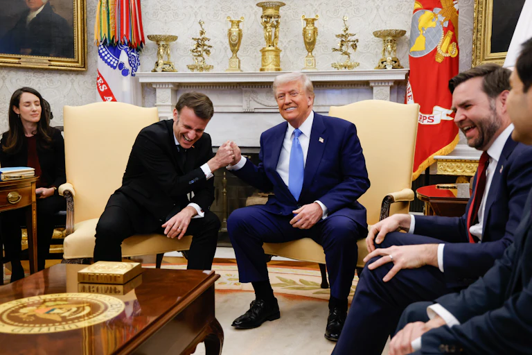 Emmanuel Macron and Donald Trump make a joke of clenching hands in the Oval Office.
