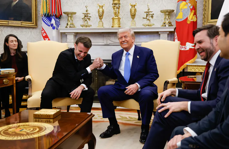 Emmanuel Macron and Donald Trump make a joke of clenching hands in the Oval Office.