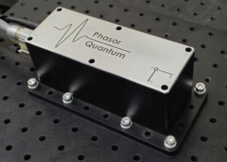 A steel box bolted to a perforated sheet with the words phasor quantum on it.